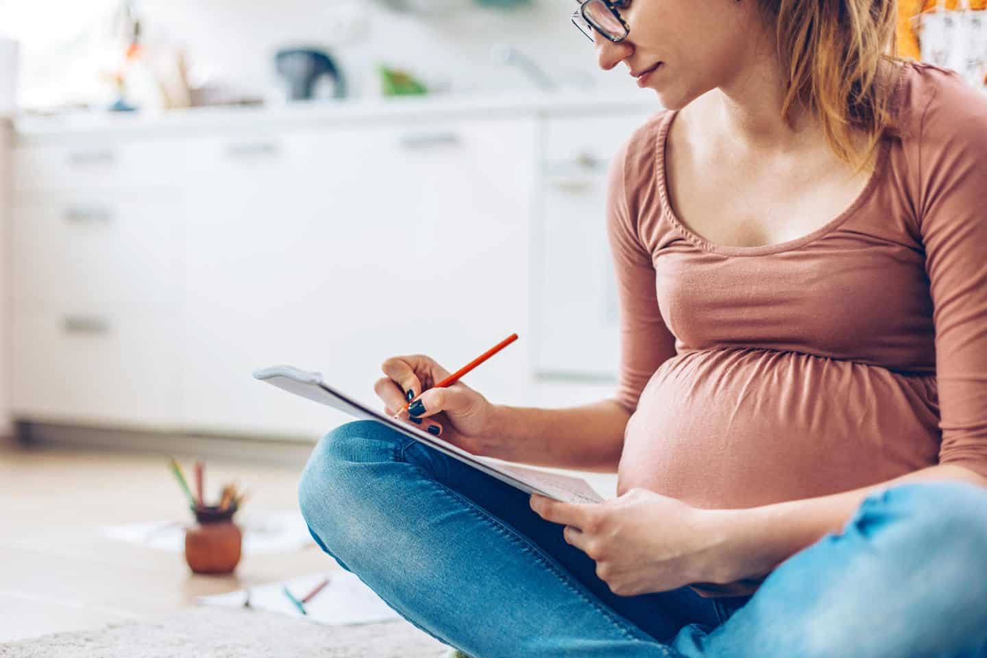 Pregnant woman drawing in a sketchbook